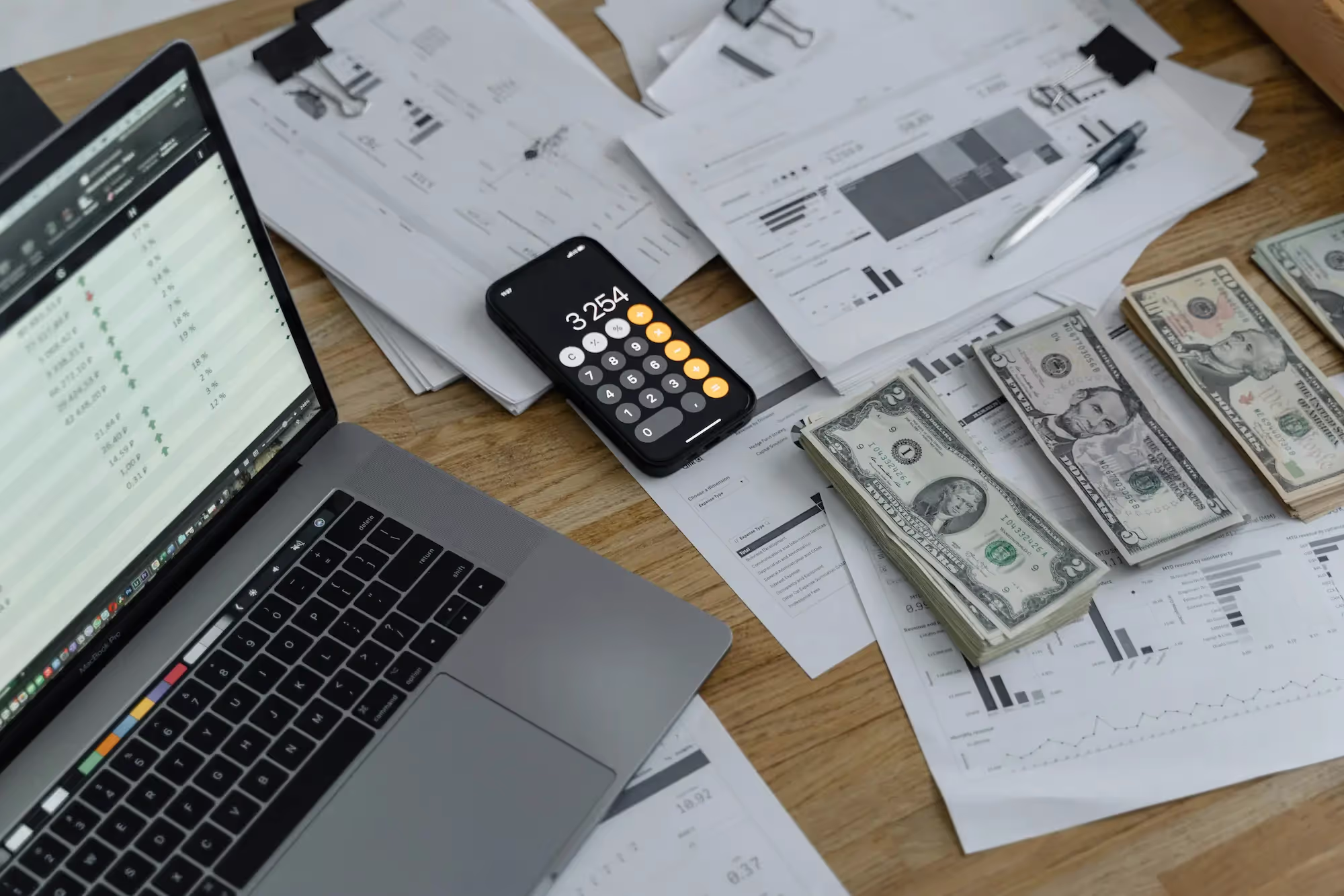 Universal Exports featuring a laptop, calculator, money, and documents highlighting budget management and financial planning